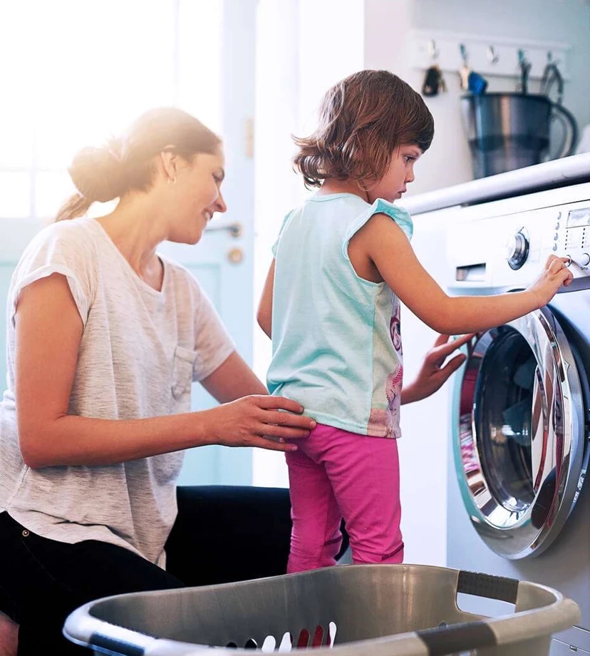 mother teaching the kid how to wash clothes